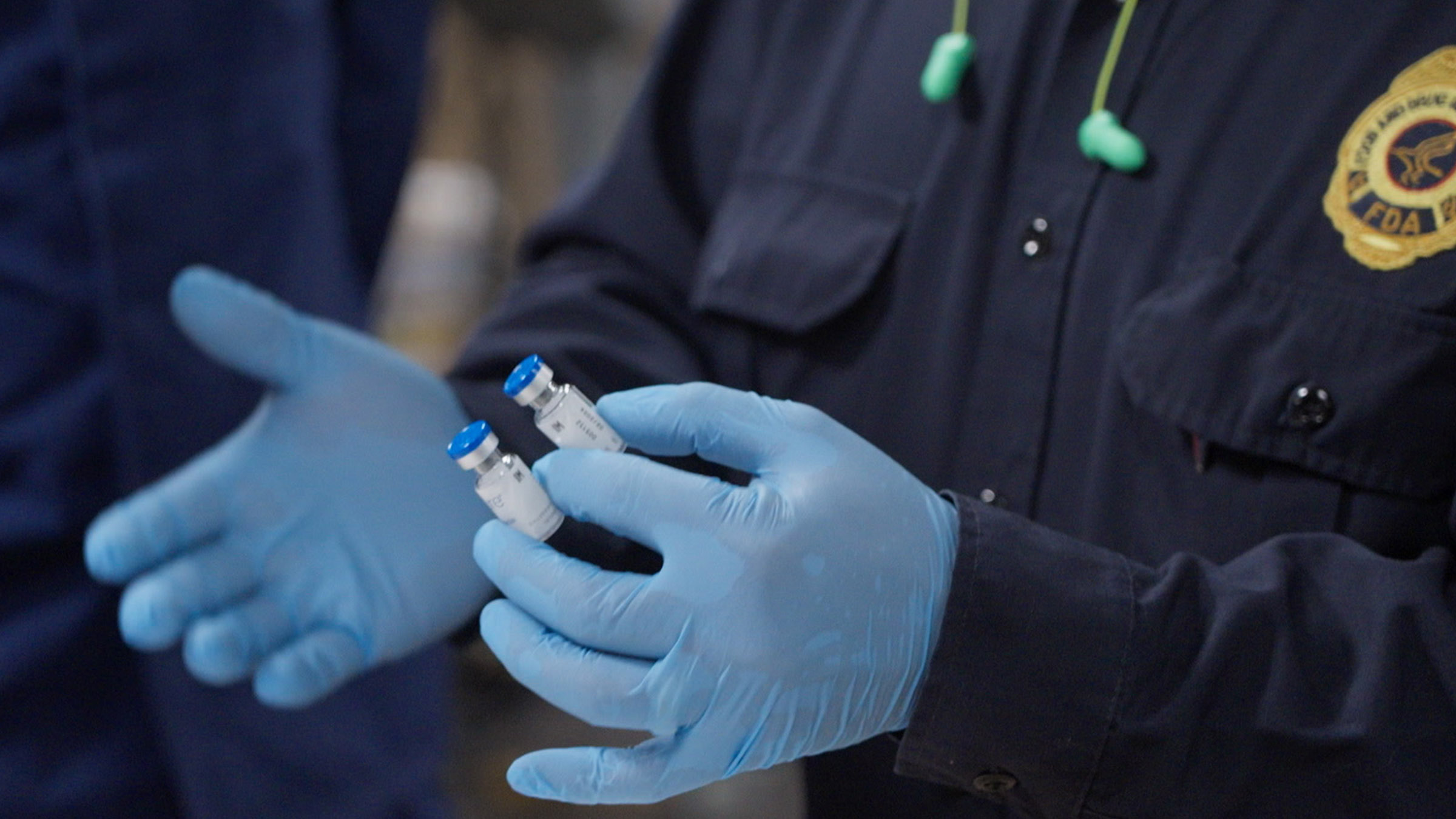An FDA officer is holding and inspecting two vials of possibly counterfeit Botox, found in a... [Photo of the day - August 2025]