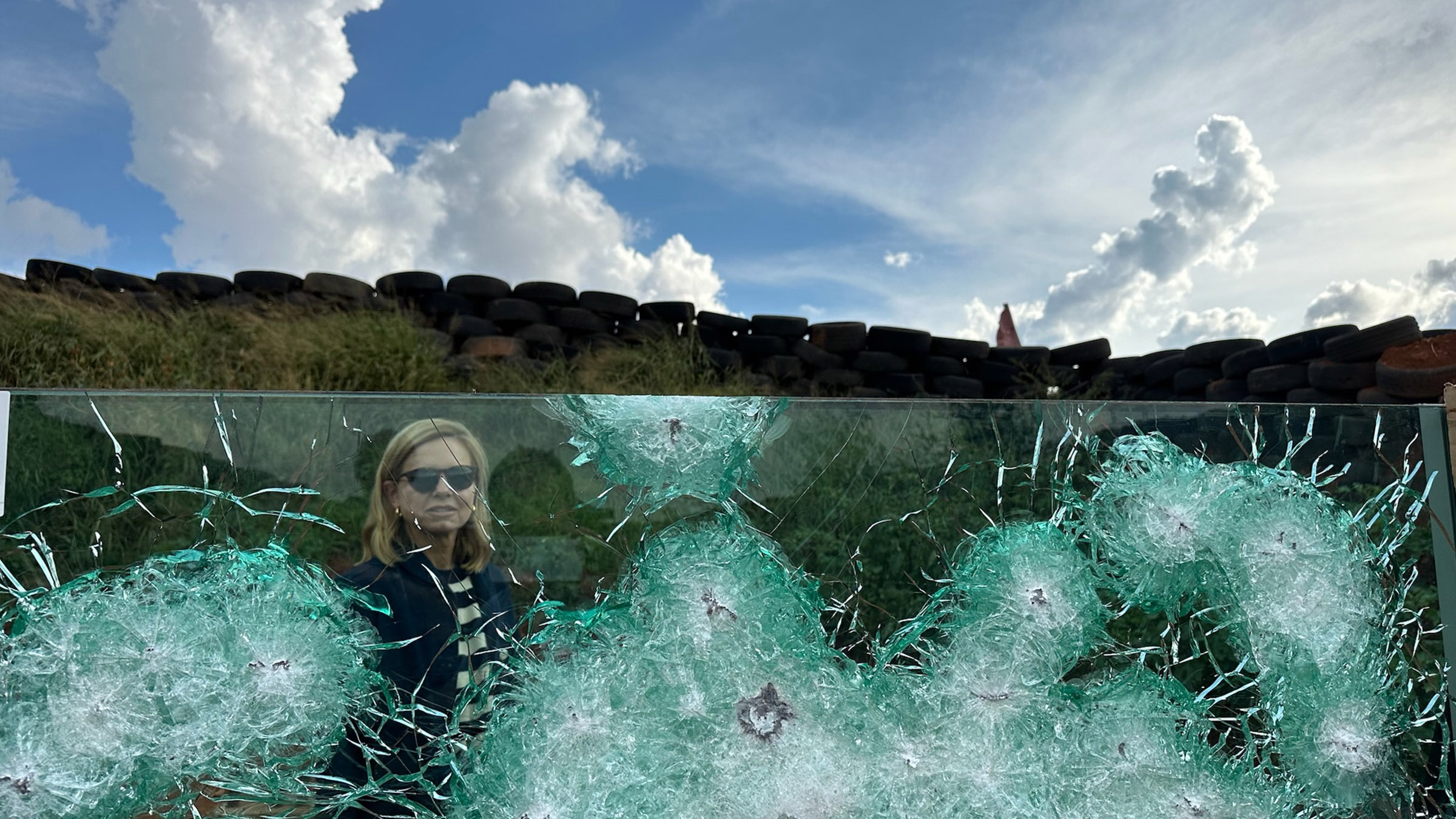 Mariana van Zeller looks through bullet-proof glass. Image from Trafficked with Mariana van Zeller. [Photo of the day - October 2025]