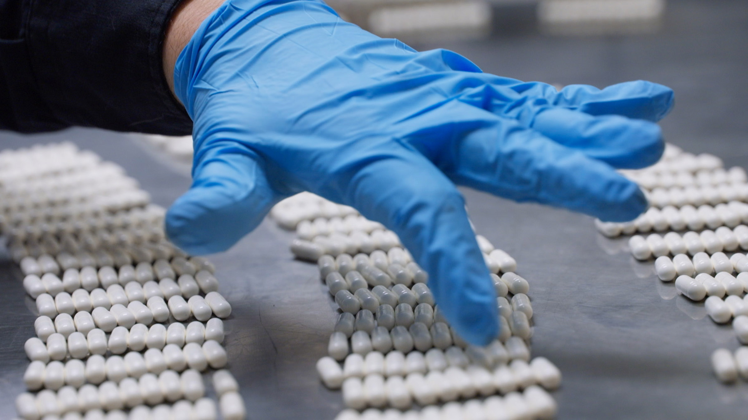 A CBP officer is wearing protective gloves while counting pills, found on a passenger's person,... [Photo of the day - December 2025]
