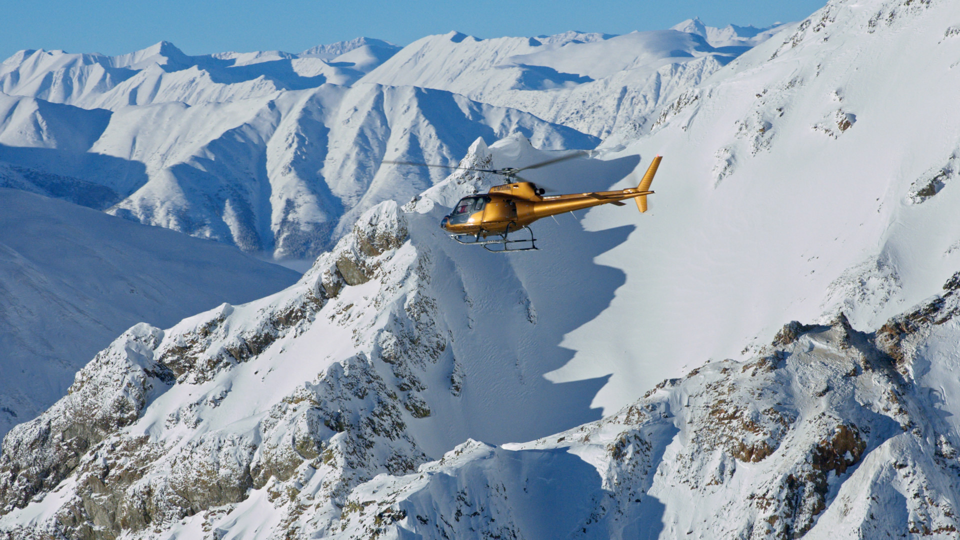Helicopter flies over mountain range. [Photo of the day - February 2026]